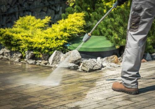 Cobble Brick Driveway Pressure Washing by Worker.